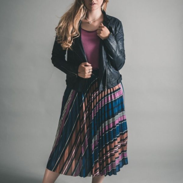Soaked in Luxury Pippa Pleated Skirt in purple worn with the Columbine Tee and Sandwich Pleather Biker Jacket, all available on colmershill.com
