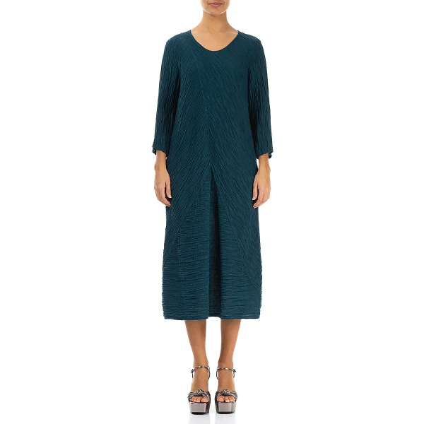 Grizas crinkled dress in dark teal is made of silk and linen. It has a slightly balloon shaping which is very flattering to many shapes and sizes. Available on Colmershill.com, UK stockist of Grizas