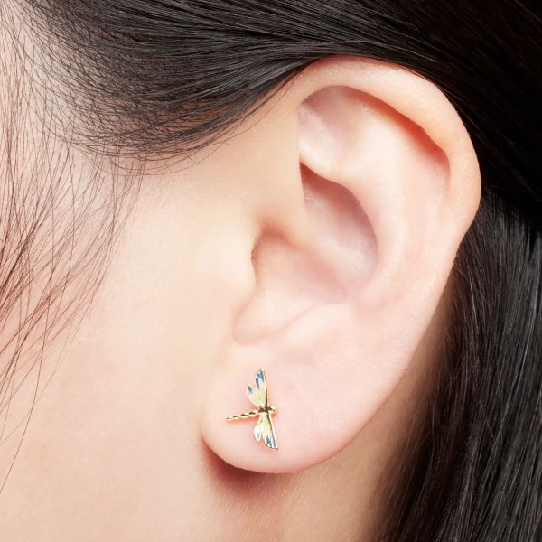 The Enamel Dragonfly Stud Earrings with their delicate wings are a masterpiece of hand-painted artistry, shimmering with vibrant hues as if catching the sunlight