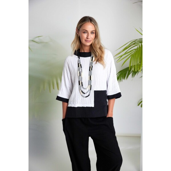 The Naya Embossed Jacquard Top delivers contemporary structure with refined detailing, offering a fresh interpretation of the summer funnel neck silhouette.