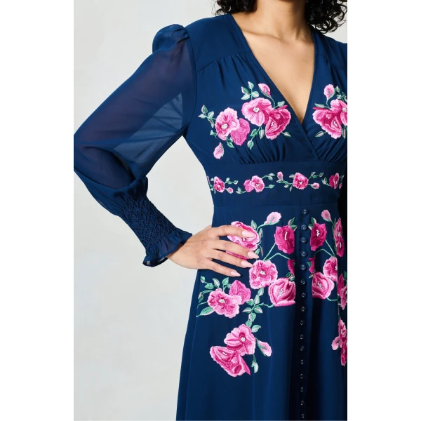 Close-up of pink floral embroidery on midnight blue dress