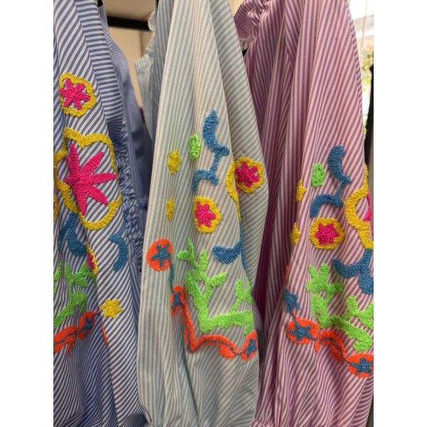 Detail of neon embroidered floral puff sleeve on striped shirt