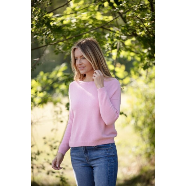 Woman wearing a super soft pink cashmere-feel jumper with dropped shoulders